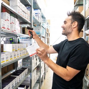 ;itarbeiter Rhino Saggiomo der HMS Medizintechnik Bauer GmbH am Regal für Sprechstundenbedarf und Praxisbedarf